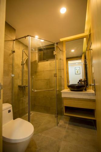 a bathroom with a shower and a toilet and a sink at TONY ESTATES Danang Beach Luxury Apartments in Danang