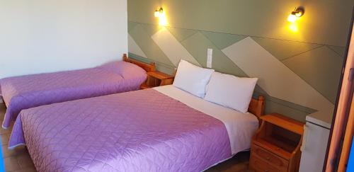 two beds in a room with purple blankets and pillows at Fantasia House in Alonnisos Old Town