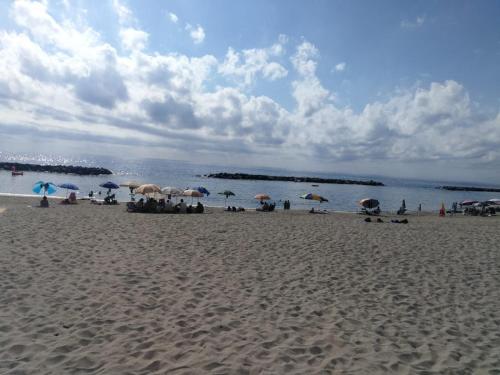 a group of people sitting on a beach with umbrellas at B&B Crispino in Belvedere Marittimo