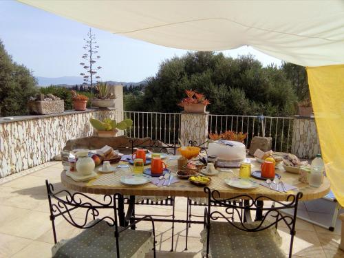 a table with food and orange juice on a patio at Casa d' Artista B&B in Ozieri