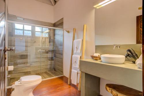 a bathroom with a shower and a toilet and a sink at A Casa de Gabriella in Itacaré