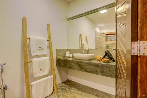 a bathroom with a sink and a mirror at A Casa de Gabriella in Itacaré
