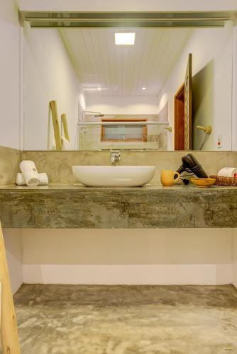 a bathroom with a sink and a mirror at A Casa de Gabriella in Itacaré