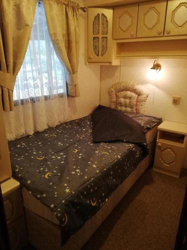 a small bed in a room with a window at Domki holenderskie na Mazurach in Dźwierzuty
