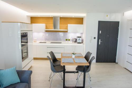 een keuken en eetkamer met een tafel en stoelen bij Apartament IDEAL in Dziwnów