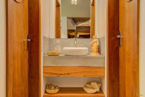 a bathroom with a sink and a mirror at A Casa de Gabriella in Itacaré