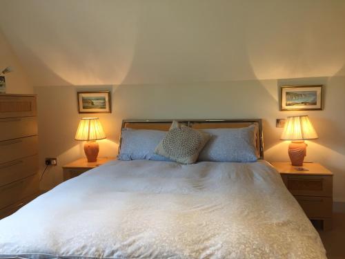 a bedroom with a white bed with two lamps at Martlets B&B in Shanklin