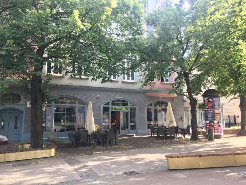 een restaurant met tafels en parasols voor een gebouw bij Pocztówka Spod Dachu in Sopot