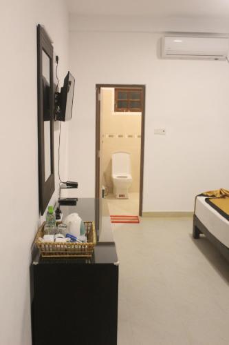 a room with a bathroom with a toilet and a mirror at Hotel Senora in Kataragama