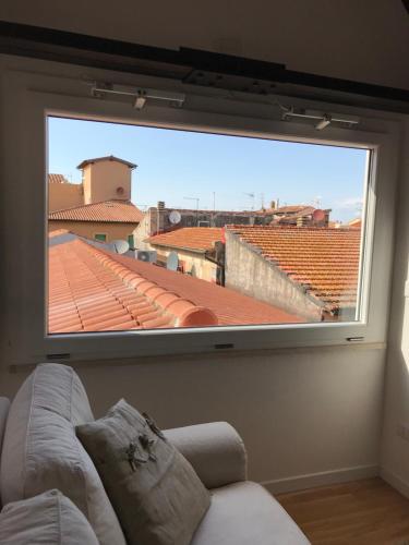 a large window in a living room with a couch at Cinema House Apartments in Orbetello