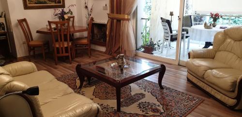 ein Wohnzimmer mit einem Sofa und einem Couchtisch in der Unterkunft Sava’s apartment in Varkiza