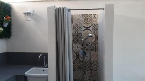 a bathroom with a shower door with a toilet at Casa del Sole in Marina di Ragusa