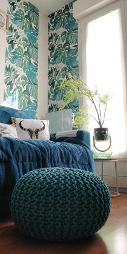 - un canapé bleu dans une chambre avec une grande fenêtre dans l'établissement Studio Royal by Beds4Wanderlust - Place du marché avec parking privé, à Fontainebleau