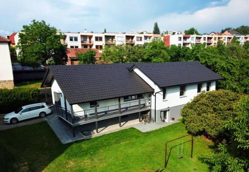 a white house with a car parked in front of it at Pozlovice - Apartmán Sisi in Luhačovice