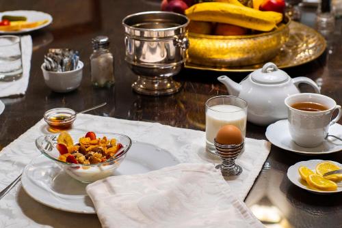 a table with a bowl of fruit and a cup of milk at Torre dei Lari Residenza d'Epoca in Florence