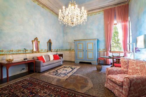 un soggiorno con divano e lampadario pendente di Torre dei Lari Residenza d'Epoca a Firenze