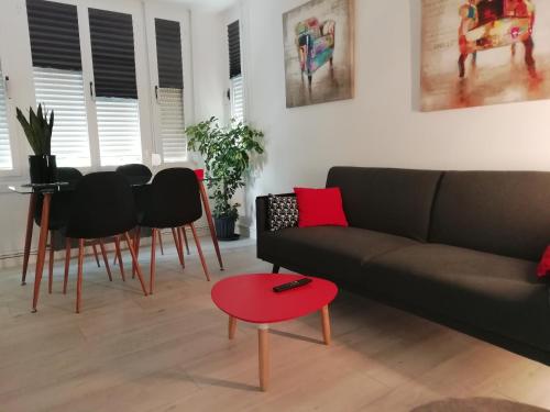 sala de estar con sofá y taburete rojo en Apartamento Somosierra a 7 minutos del centro histórico, en Logroño