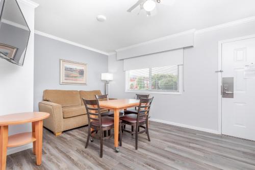 a living room with a table and chairs and a couch at Westridge Motor Inn in Osoyoos
