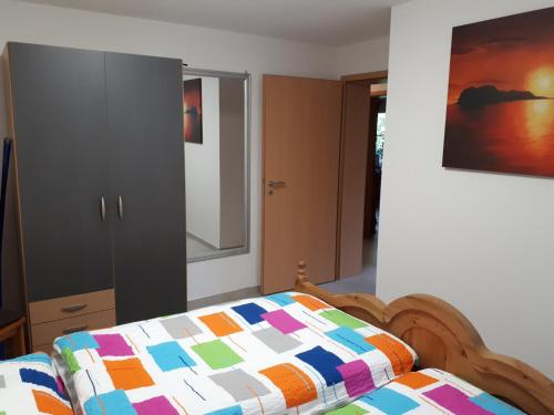 a bedroom with a bed and a cabinet and a painting at Ferienwohnung am Sorpesee in Allendorf