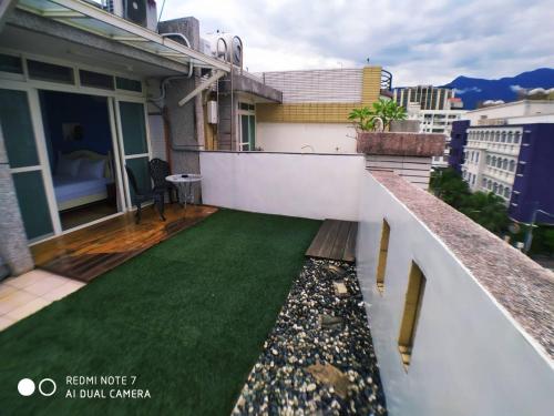 a balcony with a green lawn on a house at 玖拾捌民宿-98bnb in Hualien City