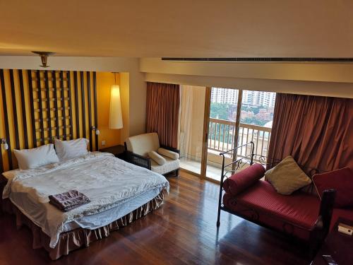 Sunway Luxury Suites في Kampong Penaga: غرفة نوم بسرير واريكة وبلكونة