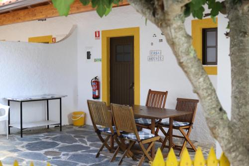 a table and chairs in front of a building at Quinta de Vale Escuro in Lousã