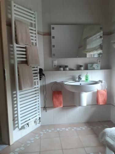 a white bathroom with a sink and a mirror at Ferienwohnung Reddemann in Westerstede