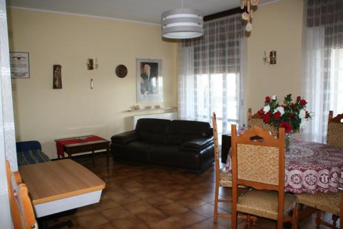 a living room with a black couch and a table at Casa Anna in Caprino Veronese