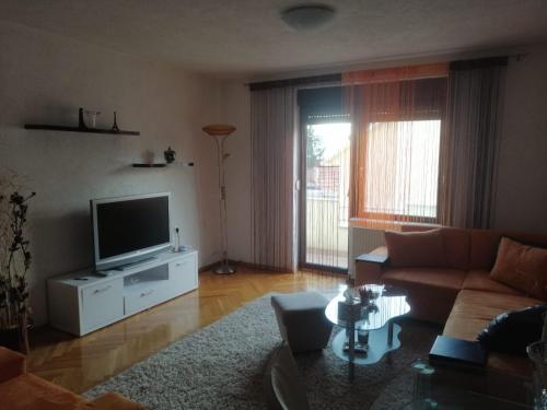 un soggiorno con divano e TV di Apartman AS a Livno
