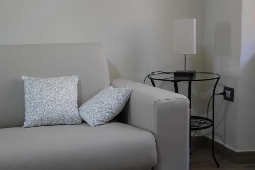 a white couch with two pillows sitting next to a table at Daniele Guest Apartment in Pistoia