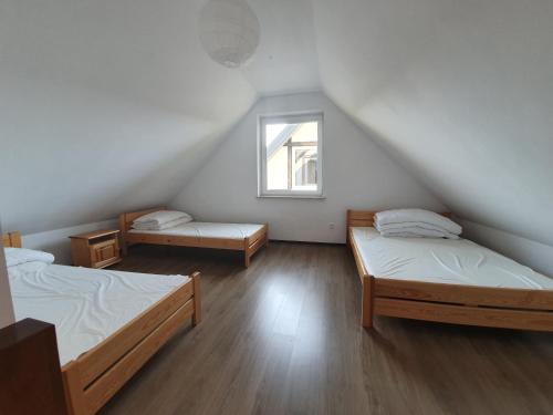 a room with two beds and a window at Przystanek Lato in Jarosławiec