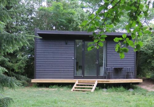 une petite maison bleue avec une terrasse couverte et une terrasse dans l'établissement Ferieidyl, à Kettinge