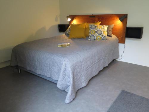 una camera da letto con un grande letto con cuscini gialli di Ferieidyl a Kettinge