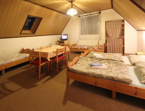 a room with two beds and a table and a dining room at Privat Lucia in Nová Lesná