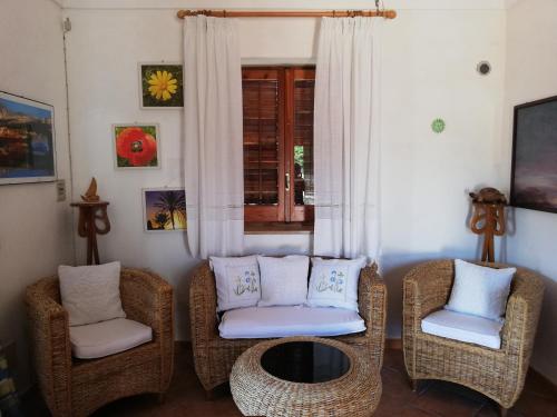 un soggiorno con tavolo e sedie in vimini di Le Case Di Tufo Riccio di mare a Favignana