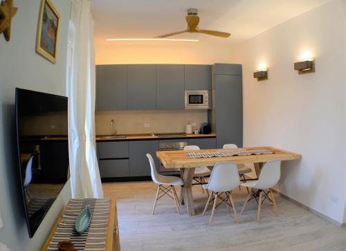 Una cocina con una mesa de madera y sillas blancas. en CaseMaggi Beach House Terrace, en Portovenere