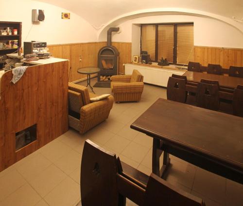 un restaurante con mesa, sillas y estufa de leña en Privat Lucia, en Nová Lesná