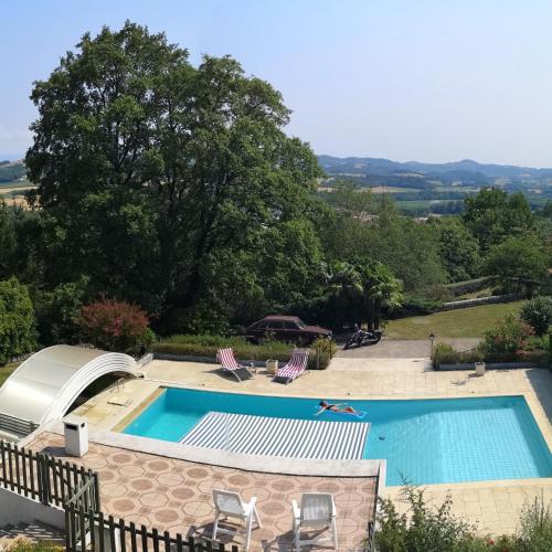 - une piscine avec 2 chaises longues à côté dans l'établissement Bellevue, à Châteauneuf-de-Galaure