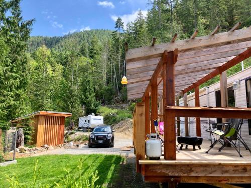 a large wooden deck with a car parked in a yard at Garden Bay Hideaway - Glamping & RV in Garden Bay