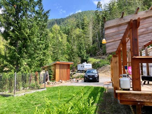 a house with a car parked in a yard at Garden Bay Hideaway - Glamping & RV in Garden Bay