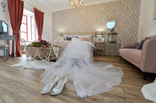 a wedding dress and shoes on a bed in a room at Křišťanka - kouzelné apartmány in Prachatice