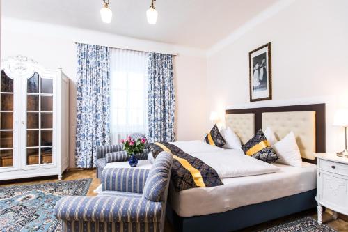 アルタウスゼーにあるHotel am See - Seeresidenzのベッドルーム1室(ベッド1台、ソファ、椅子付)