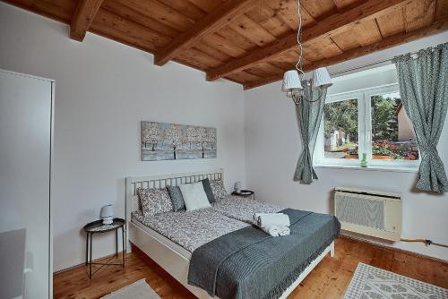 a bedroom with a bed and a window at Twin Pines Apartment in Egerszalók
