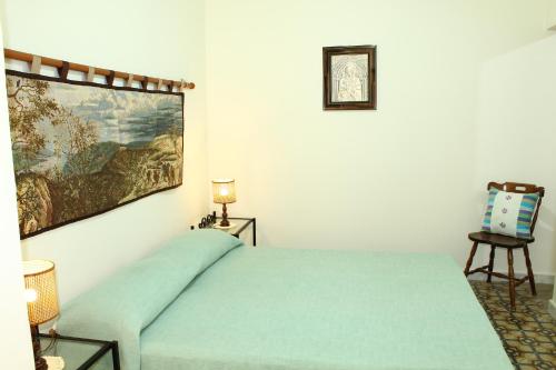 una camera con un letto verde e un dipinto sul muro di Borgo del Barone a Carini