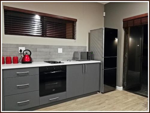 a kitchen with a stove and a refrigerator at Studio 77 in Langebaan
