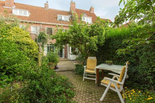 a garden with a table and chairs in front of a house at Residentie Blijdorp in Rotterdam