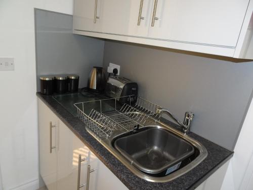 a kitchen counter with a sink and a microwave at St Margaret's House in Leamington Spa