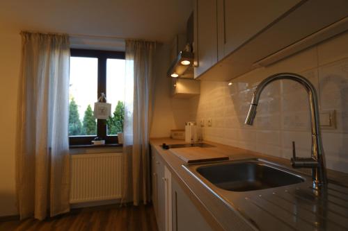 una cucina con lavandino e finestra di Villa Czarli a Międzyzdroje