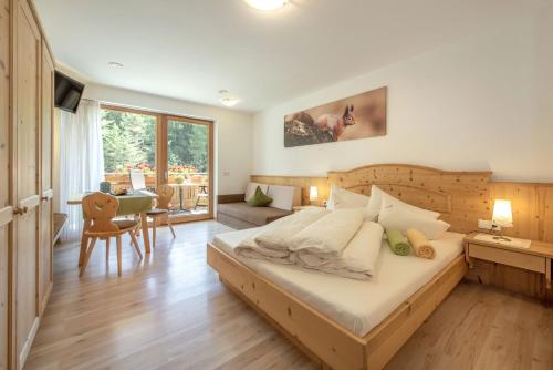 een slaapkamer met een groot bed en een woonkamer bij Apartmenthaus Fuchsmaurer in Bressanone