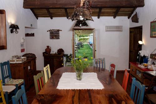 a dining room table with a vase of flowers on it at Casa Da Seiceira in São Teotónio